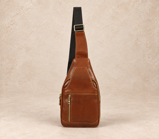 Cognac brown leather sling bag AIL-BB-0007 with black webbing strap, shown from the front