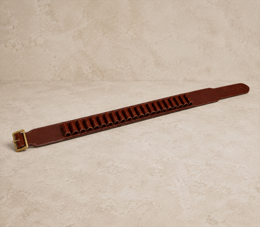 Cognac Brown Leather Cartridge Belt AIL-HP-0010 angled flat-lay view on warm limestone studio background