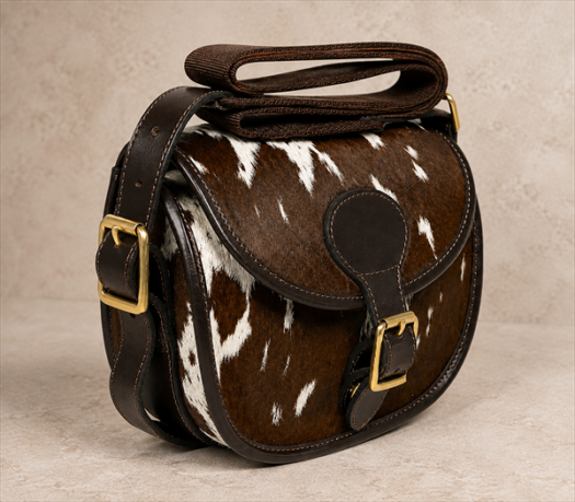 Brown and White Hair-on-Hide Hunting Bag AIL-HP-0018 front three-quarter view on warm limestone studio background